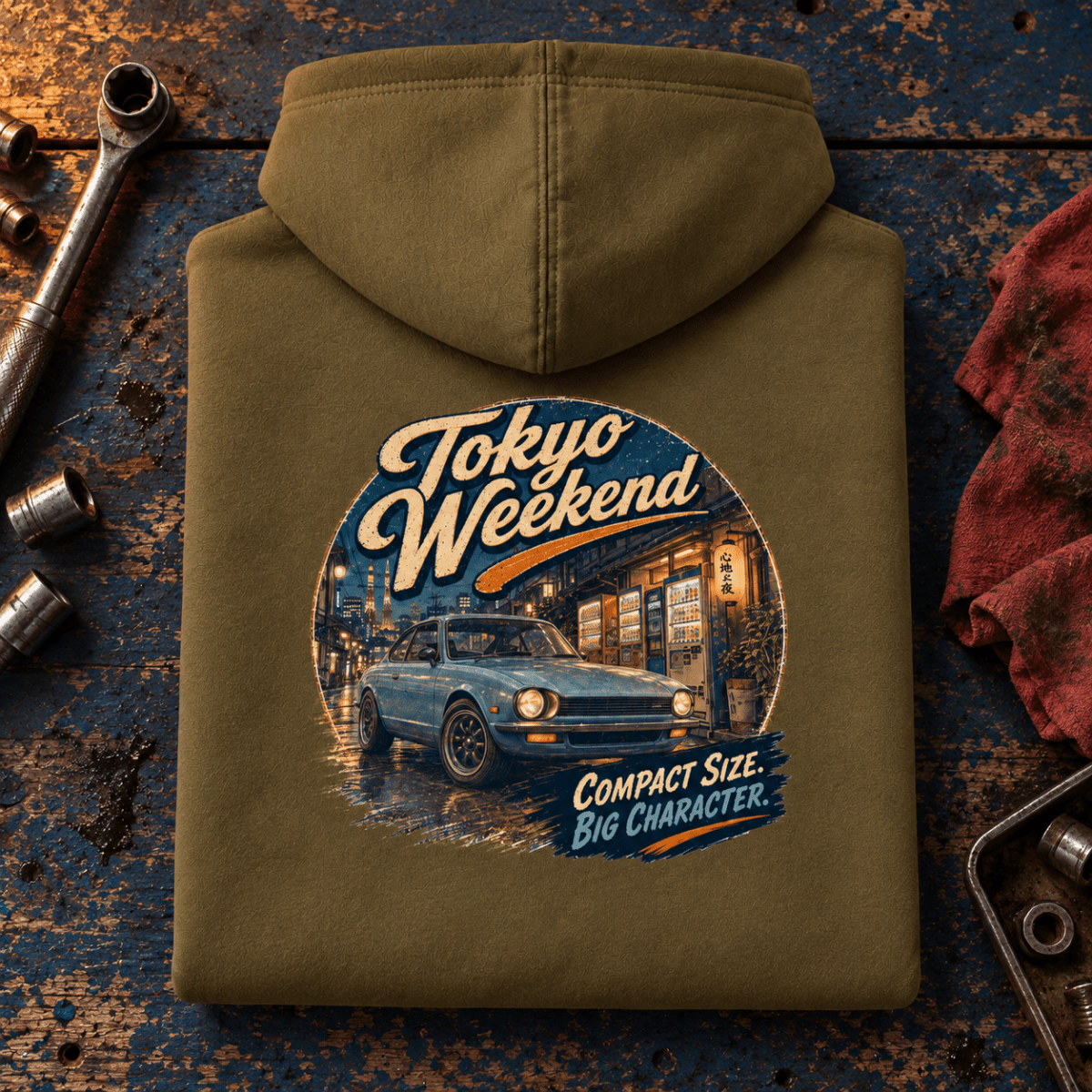 JDM Car Graphic Hoodie – Tokyo Weekend Classic Compact Street Car, folded back hero on a worn automotive workbench – car-hd-0057