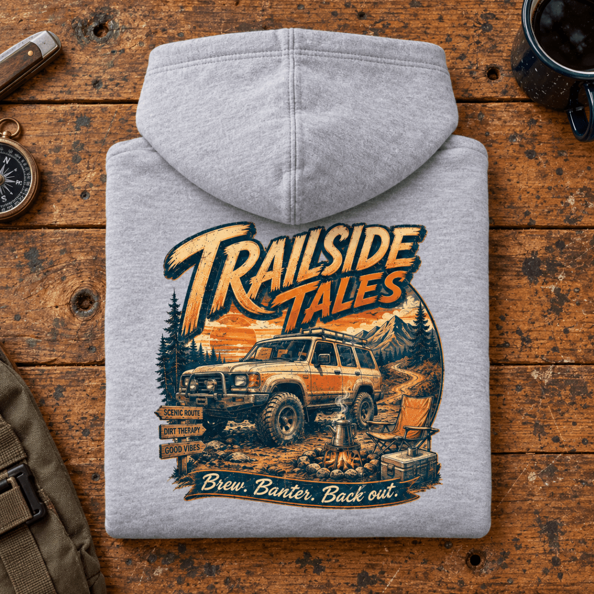 Folded heather grey Trailside Tales Adventure hoodie back on a workshop bench — car-hd-0006