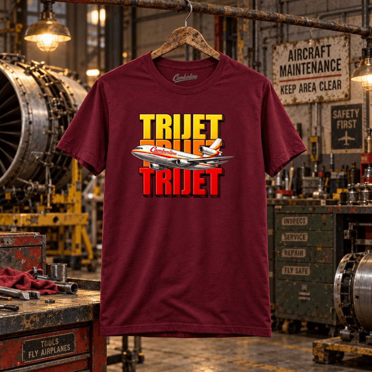 Burgundy Trijet retro three-engine airliner graphic T-shirt in a gritty aviation workshop