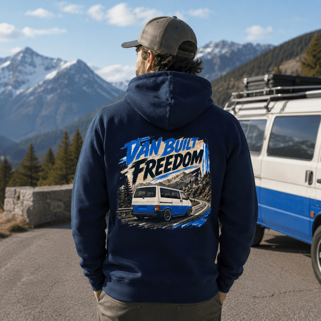Person wearing a navy hoodie with 'Van Built Freedom' design in a mountainous landscape.