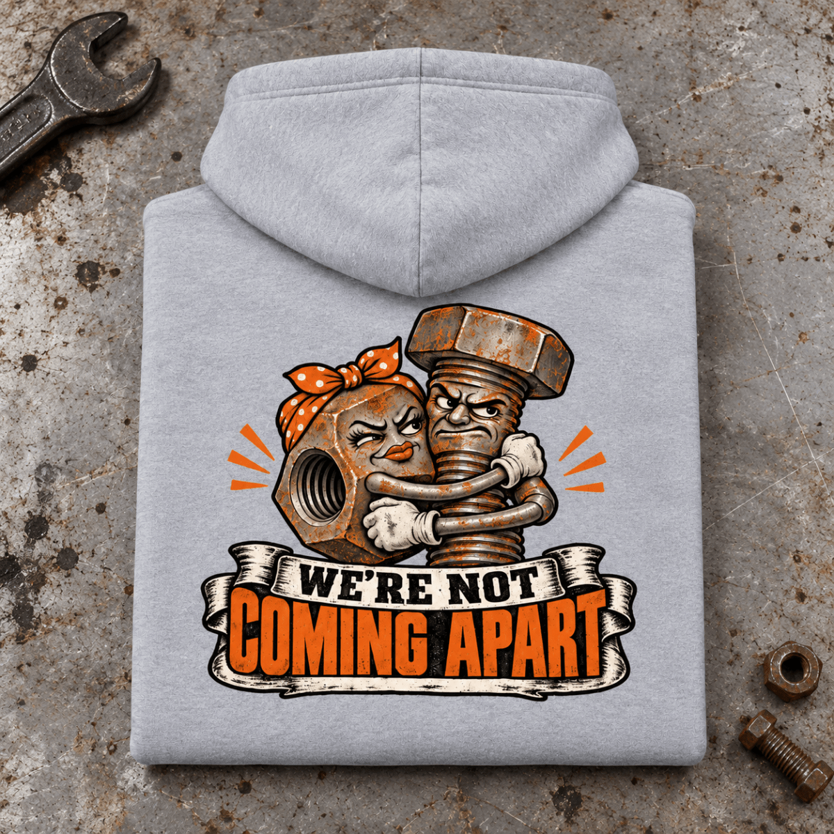 Camberline Nut and Bolt Mechanic Hoodie in heather grey, folded back view on a workshop bench with full graphic visible